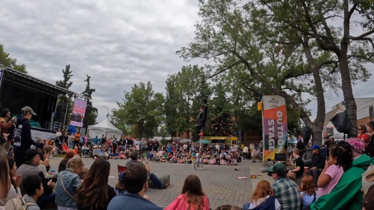 Crowds watch a street performer at the Edmonton Fringe Festival outdoor stage