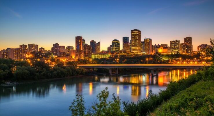 Edmonton skyline at dusk with city lights reflecting on the North Saskatchewan River